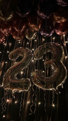 balloons and streamers are hanging in the shape of the number twenty two, surrounded by helium