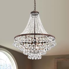 a crystal chandelier hanging from the ceiling in a room with a round window