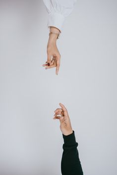 two hands reaching for each other in the air with their fingers extended up above them