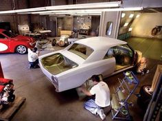 two men working on a car in a garage