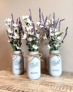 three mason jars with lavender and white flowers in them