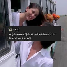 a woman standing next to a man in front of a bus on the road with words written above her