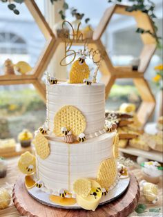 a three tiered cake decorated with honeycombs and bees