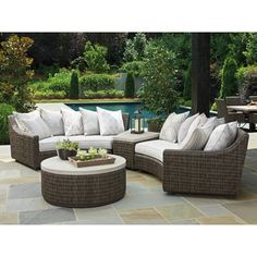 an outdoor patio furniture set with cushions and pillows on the couches, coffee table and pool in background