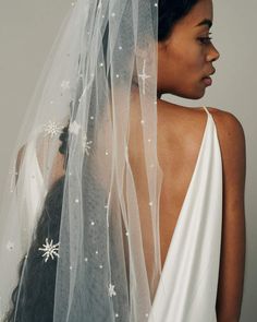 a woman wearing a wedding veil with stars on it