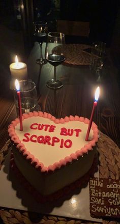 a heart shaped cake with candles on it that says cut but scorpio