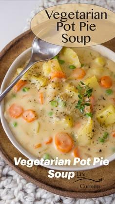 a bowl of vegetable pot pie soup with a spoon in it on a wooden plate