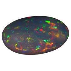 an oval black opal with green and orange colors