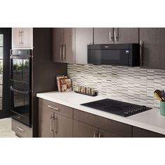 a kitchen with stainless steel appliances and white counter tops, including a microwave oven above the stove