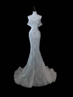 a white wedding dress on a mannequin headdress in front of a black background