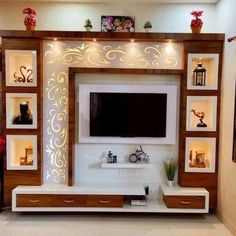 an entertainment center with built in shelving units and lights on the wall above it