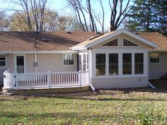 a white house with a porch in the front yard