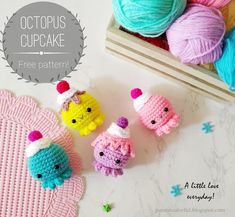 crocheted cupcakes are sitting next to some balls of yarn