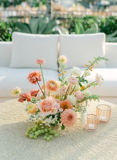 a vase filled with flowers sitting on top of a table next to two votive candles