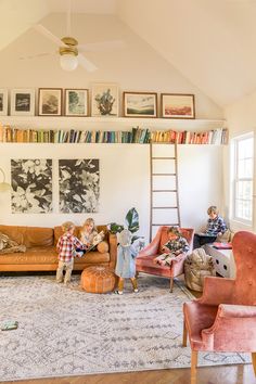 two children are playing in the living room with bookshelves and pictures on the wall