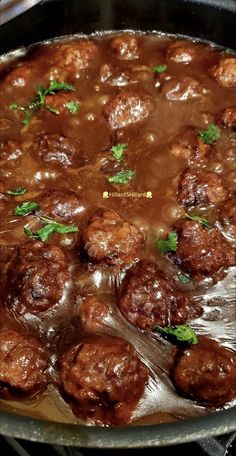 meatballs and gravy are cooking in a skillet