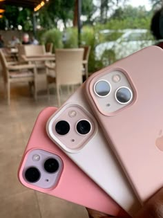 two pink iphones are being held up in front of the camera