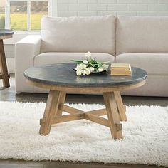 a coffee table with flowers on top in front of a couch