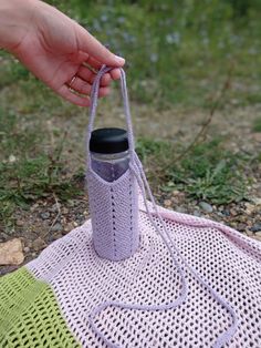 a person holding a bottle on top of a blanket