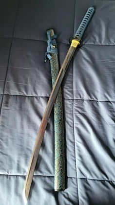 two swords laying on top of a bed next to each other