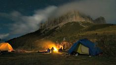 tents set up on the side of a mountain at night