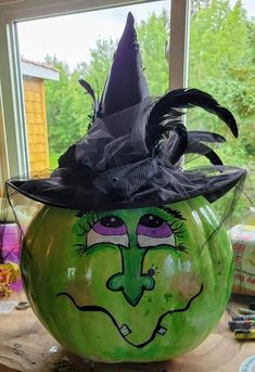 a green pumpkin with a witches hat on it