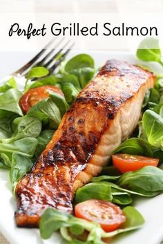 grilled salmon and spinach salad on a white plate with the words perfect grilled salmon