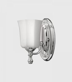 a chrome wall light with a white glass shade