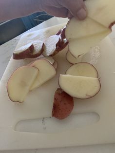 someone is peeling an apple on a cutting board