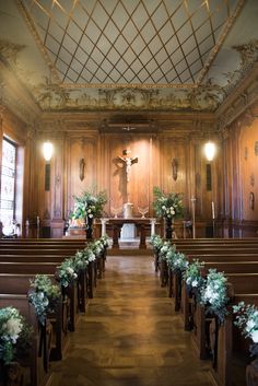 an empty church with wooden pews and floral arrangements