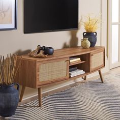 an entertainment center with a flat screen tv mounted on it's sideboard in a living room