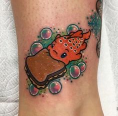 the foot has a tattoo on it with an image of a piece of food and bubbles