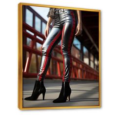 a woman in high heeled shoes standing next to a red and black fence with her hand on her hip