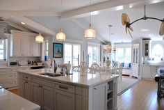 a large kitchen with an island in the middle and lots of lights hanging from the ceiling