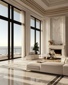 an elegant living room with large windows overlooking the ocean is shown in this image, along with two couches and a coffee table