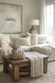 a living room with a white couch and pillows on the floor, coffee table in front of it