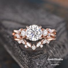 a rose gold engagement ring set with pear shaped cut diamonds on top and leaves around the band