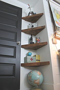 some shelves in the corner of a room with a globe and other items on it