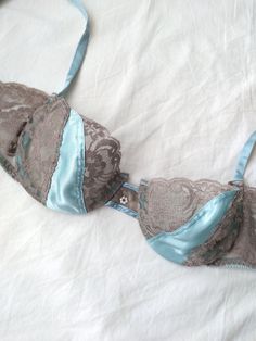 Beautiful vintage balconette bra in a light blue color by designer, Christian Dior. Features floral lace and satin cups, hook and eye closure with three hook options, underwire, and a dainty floral bead in the center. Era: Circa 1970s Condition: Excellent Size: 34C Color: Light blue, gray Brand: Christian Dior Measurements: 13in band width at the last hook Fabric Content: 60% polyester, 40% nylon (lace); 100% imported polyester (panel); 79% nylon, 21% spandex (elastic) MORE INFO: *Please, note that all items are vintage. Therefore, it is expected to find some wear. Ariessence by Ariel is an admirer of fashion history and hopes you can appreciate this garment and its character. The condition and any damages will be indicated to the best of my ability. Vintage sizes may also vary compared to Pearl Applique, Sea Blue Color, Bra Items, Vintage Christian Dior, Balconette Bra, Light Blue Color, Bra Lingerie, Fashion History, Blue Lace