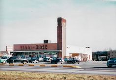 cars are parked in front of a store on the side of the road near a parking lot