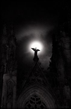 the sun shines brightly in front of an old church with gothic architecture and dark clouds