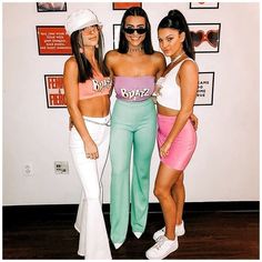 three women standing next to each other wearing matching outfits