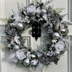 a christmas wreath with silver and white decorations