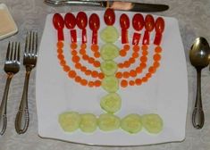 a white plate topped with sliced cucumbers and carrots next to silverware