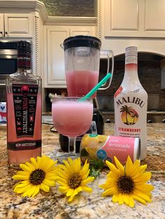 some drinks are sitting on a counter with sunflowers