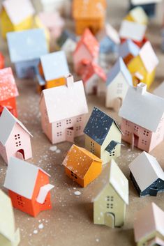 small colorful houses are scattered on the floor in front of some paint splatters