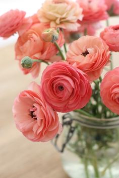 a vase filled with pink flowers on top of a wooden table