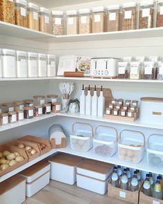 an organized pantry with lots of food and containers on the shelves in front of it