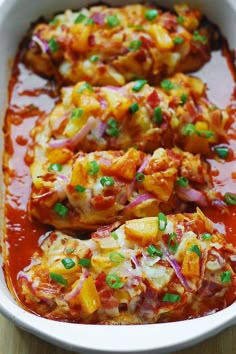 an enchilada casserole with meat and vegetables in a white dish