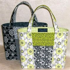 two purses sitting next to each other on top of a white surface with green and black designs